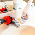 Drill Brush 3 Pack medium stiff brush attached to drill cleaning bathroom sink faucet with cleaning solution bottle nearby
